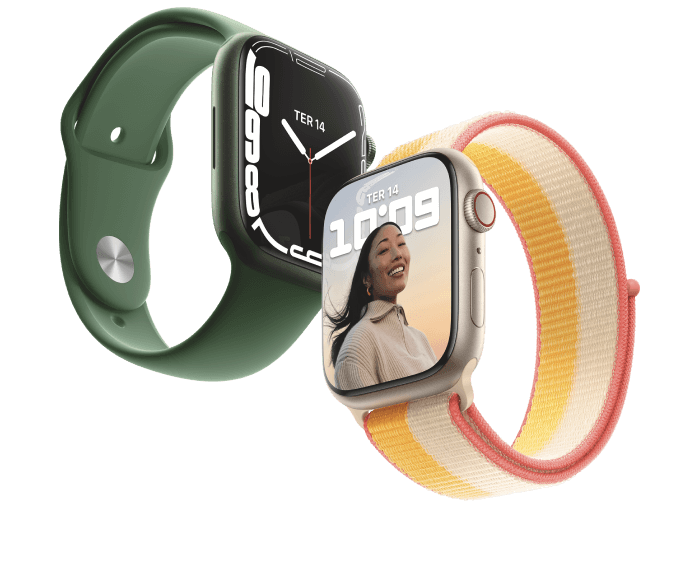 Dois Apple Watch inclinados com pulseiras de tecido e borracha. Na tela de um, há um relógio imitando o analógico. No outro, foto de uma mulher sorrindo.